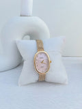 montre NAIDU doré ovale bracelet en maille fond rose poudré